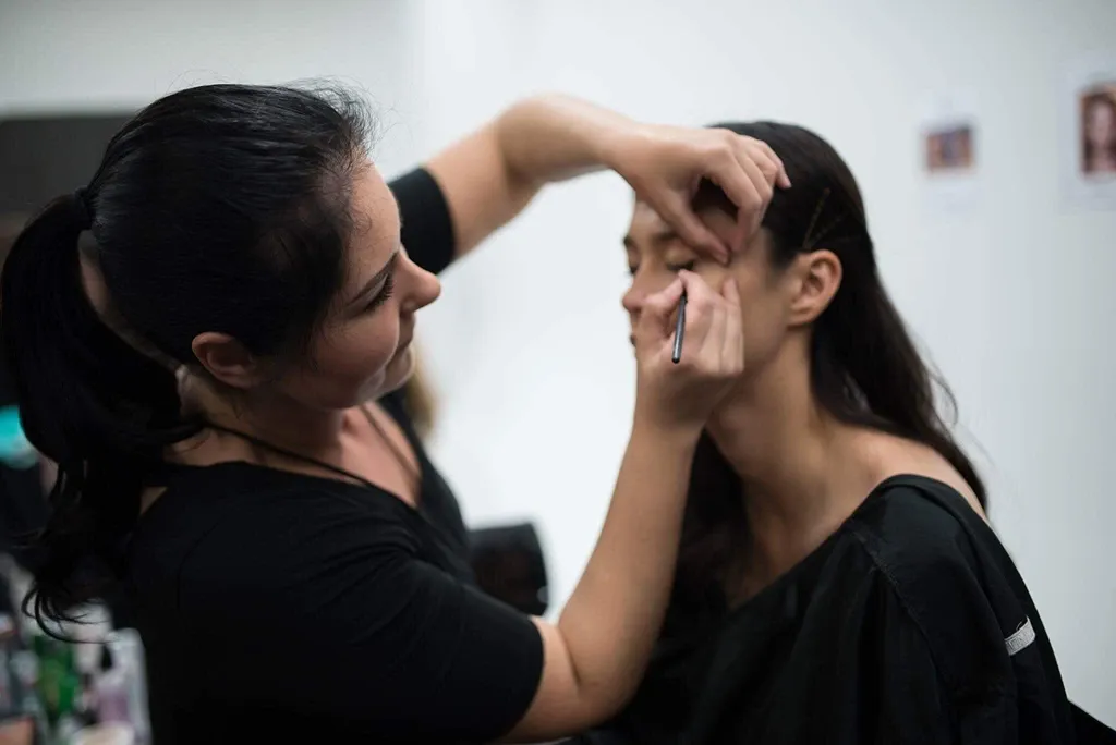 Kim applying makeup in the studio